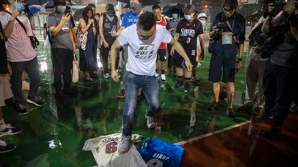 A demonstrator stomps on Lebron James jerseys during a rally at the Southorn Playground in Hong Kong, Tuesday, Oct. 15, 2019. (AP Photo/Mark Schiefelbein)
