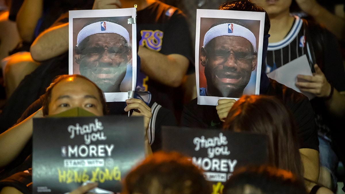 Demonstrators hold up photos of LeBron James grimacing during a rally at the Southorn Playground in Hong Kong, Tuesday, Oct. 15, 2019. (AP Photo/Mark Schiefelbein)