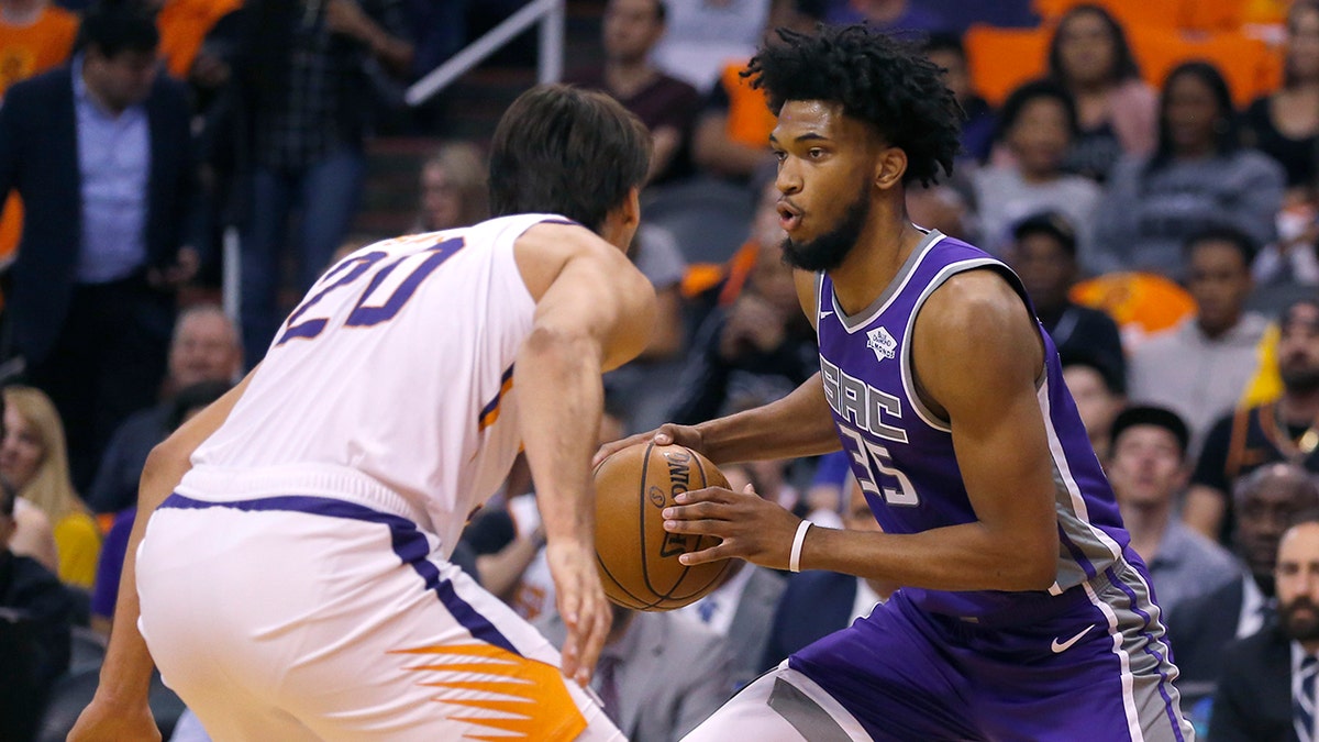 Sacramento Kings forward Marvin Bagley III drives on Phoenix Suns forward Dario Saric (20) during the first half of an NBA basketball game Wednesday, Oct. 23, 2019, in Phoenix. (AP Photo/Rick Scuteri)