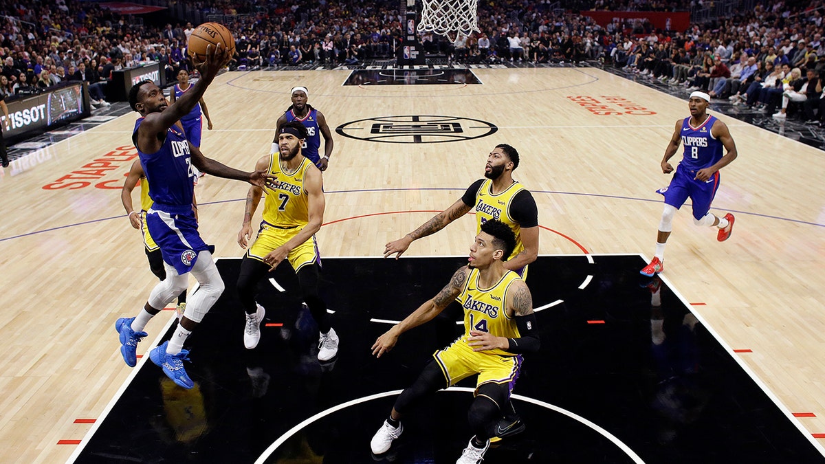 Los Angeles Clippers' Patrick Beverley, left, drives to the basket against the Los Angeles Lakers during the first half of an NBA basketball game Tuesday, Oct. 22, 2019, in Los Angeles. (AP Photo/Marcio Jose Sanchez)
