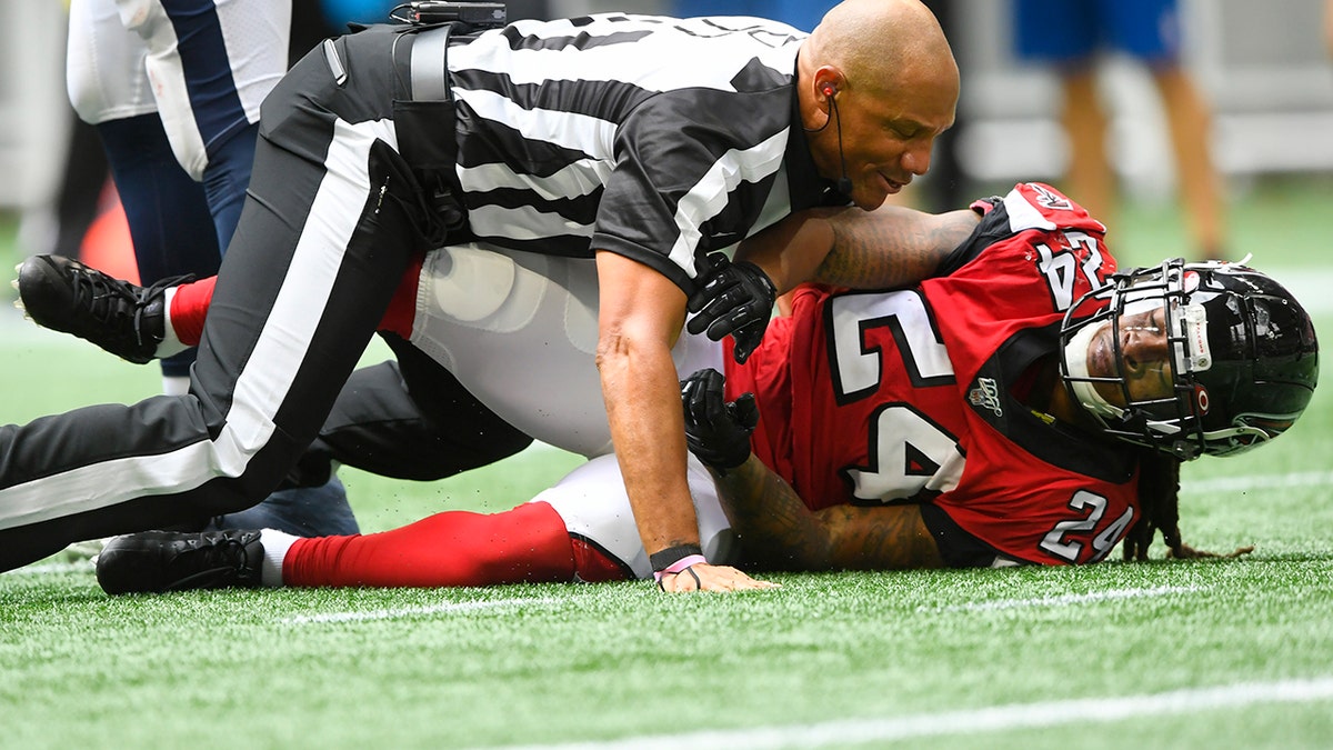 Referee Terry McAulay (77) breaks up an altercation between Atlanta Falcons running back Devonta Freeman (24) and Los Angeles Rams defensive tackle Aaron Donald during the second half of an NFL football game, Sunday, Oct. 20, 2019, in Atlanta. (AP Photo/John Amis)