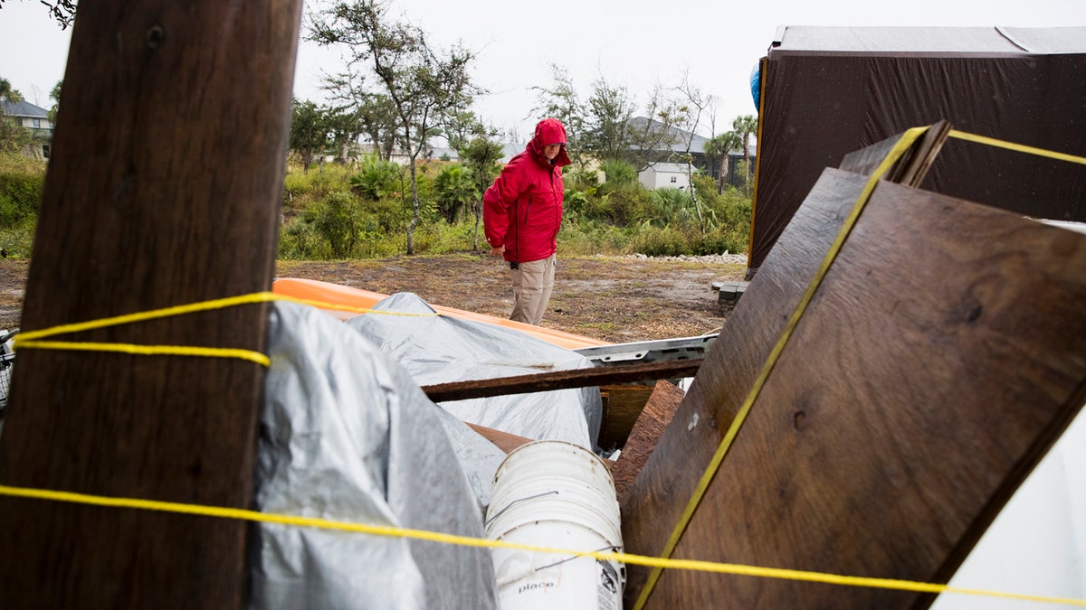 Chris Anderson ties down building materials and other objects from his lawn as Tropical Storm Nestor approached Mexico Beach, Fla..