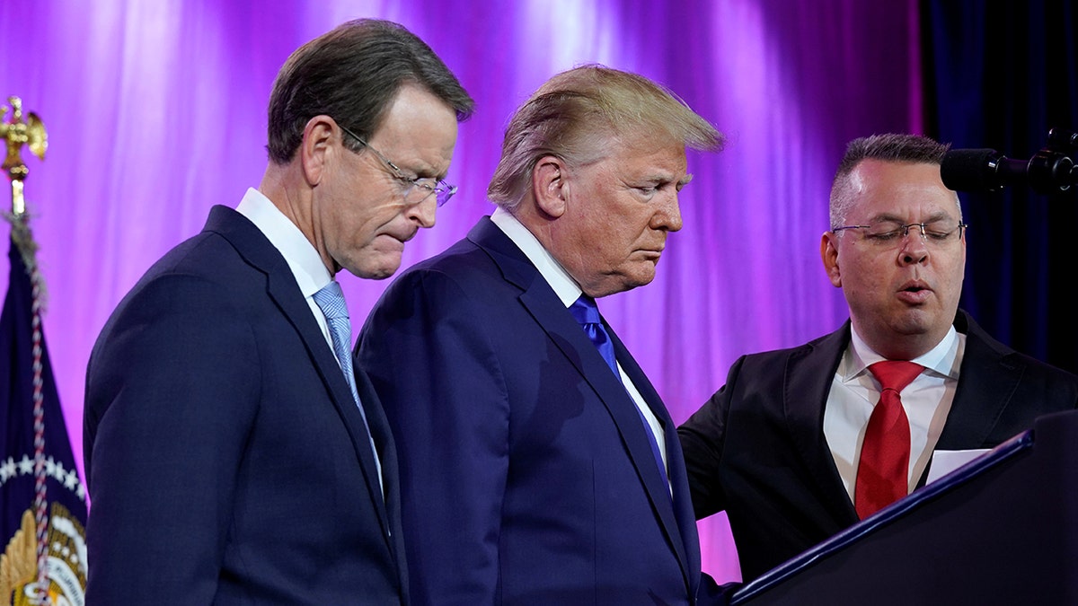 Former President Trump prays between Tony Perkins, president of the Family Research Council, and Pastor Andrew Brunson at the Family Research Council's annual gala in Washington, D.C., Oct. 12, 2019. 