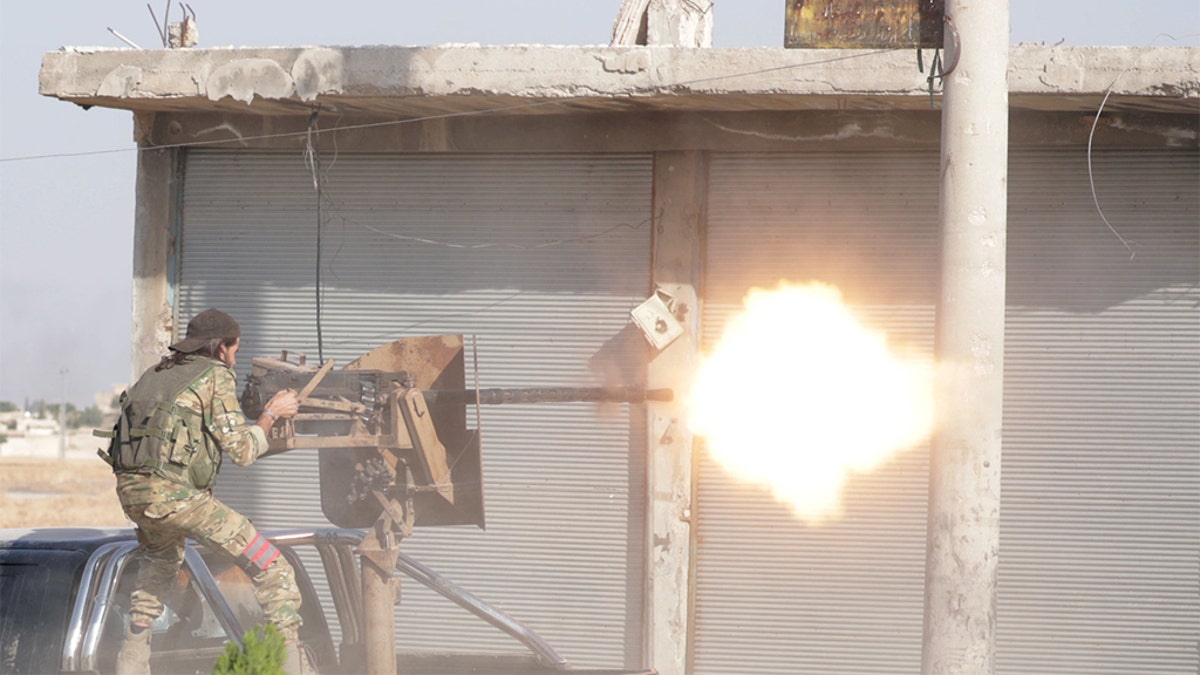 A Turkey-backed Syrian rebel fighter fires a weapon in the town of Tal Abyad, Syria October 13, 2019. REUTERS/Khalil Ashawi - RC16435E4ED0