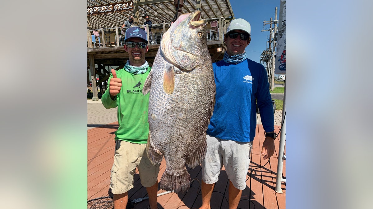 Jorgensen and Blake Rigby with the massive tripletail at Cypress Cove Marina.