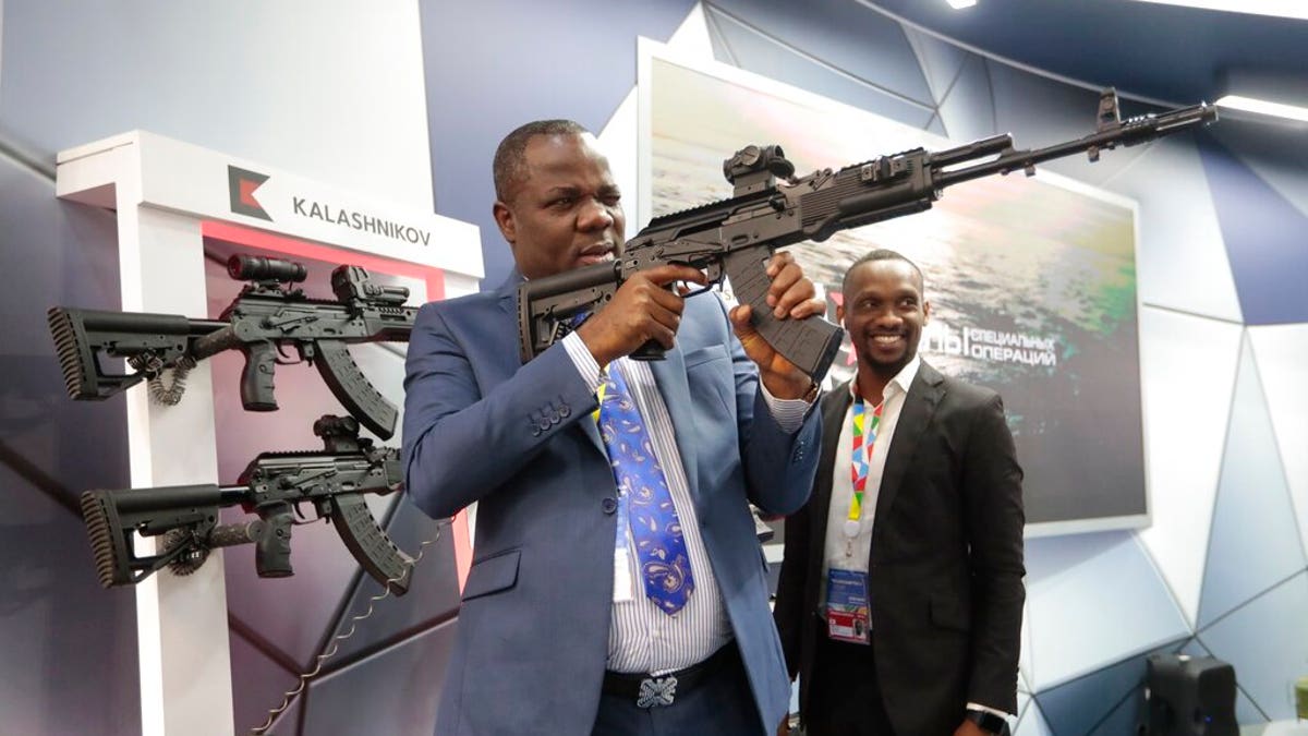 A visitor examines a Kalashnikov weaponry at an exhibition by Kalashnikov company on the sidelines of African countries at the Russia-Africa summit in the Black Sea resort of Sochi, Russia, Thursday, Oct. 24, 2019.