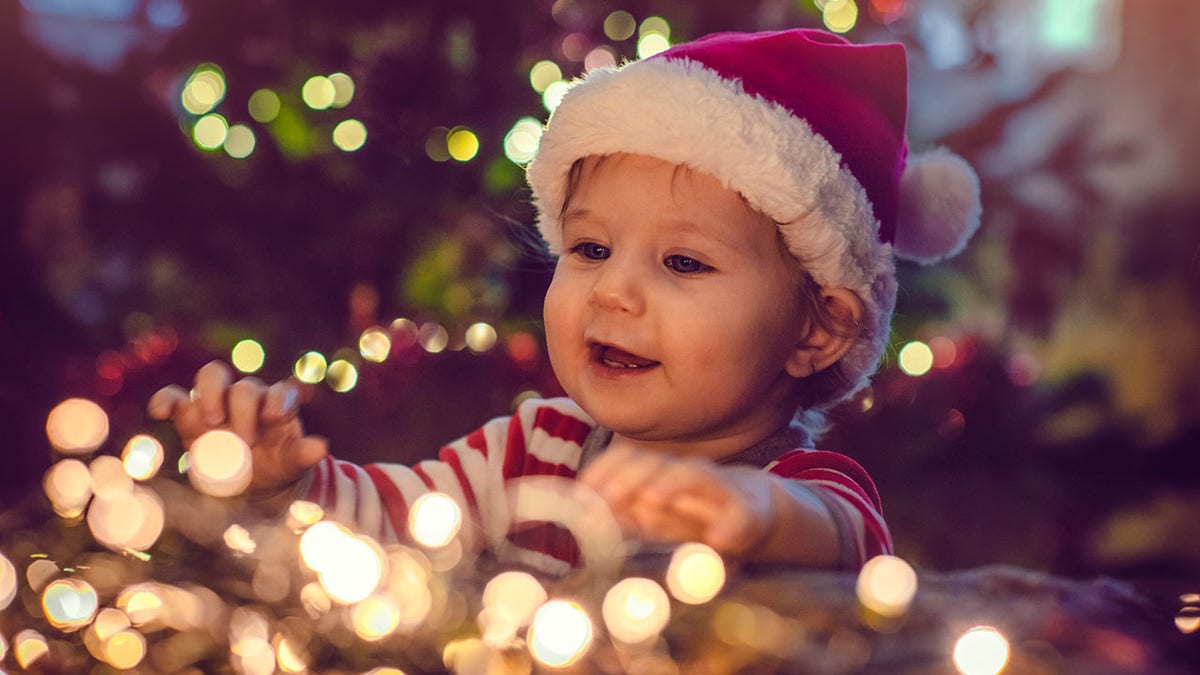 baby playing with Christmas lights