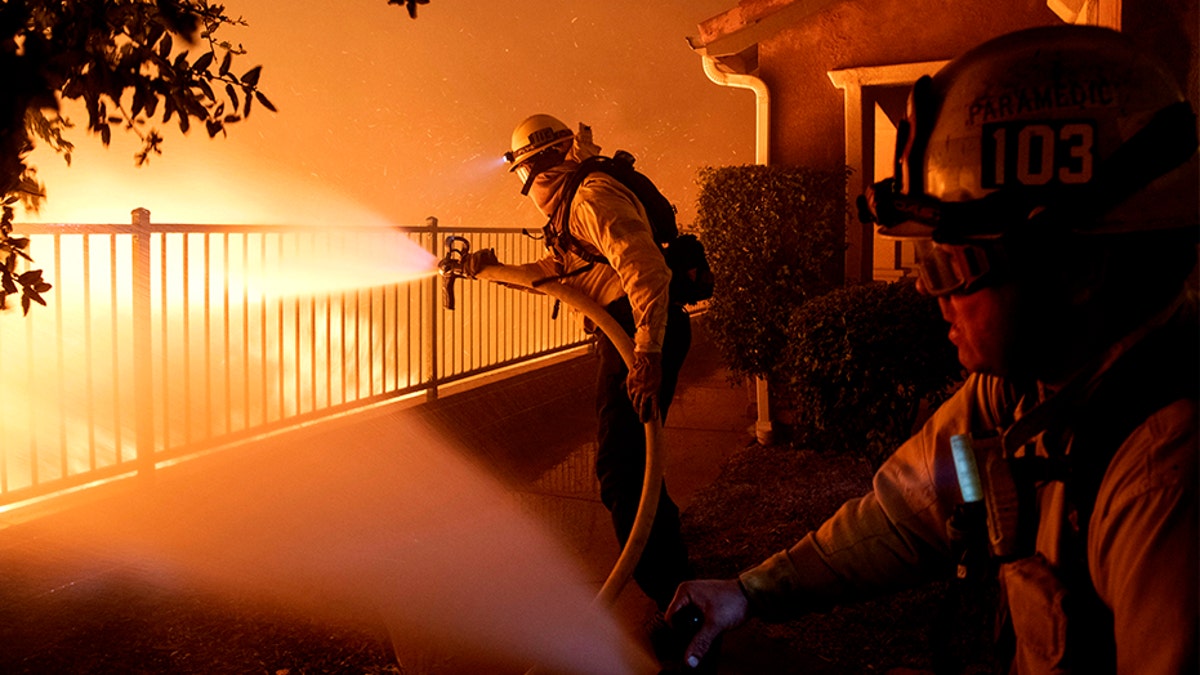 Los Angeles City firefighters battle the Saddleridge fire near homes in Sylmar, Calif., on Thursday.
