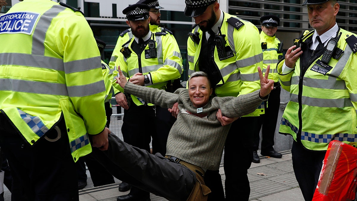 A climate change protester is arrested outside the Home Office in London, Tuesday, Oct. 8, 2019. Police are reporting they have arrested more than 300 people at the start of two weeks of protests as the Extinction Rebellion group attempts to draw attention to global warming. (AP Photo/Alastair Grant)