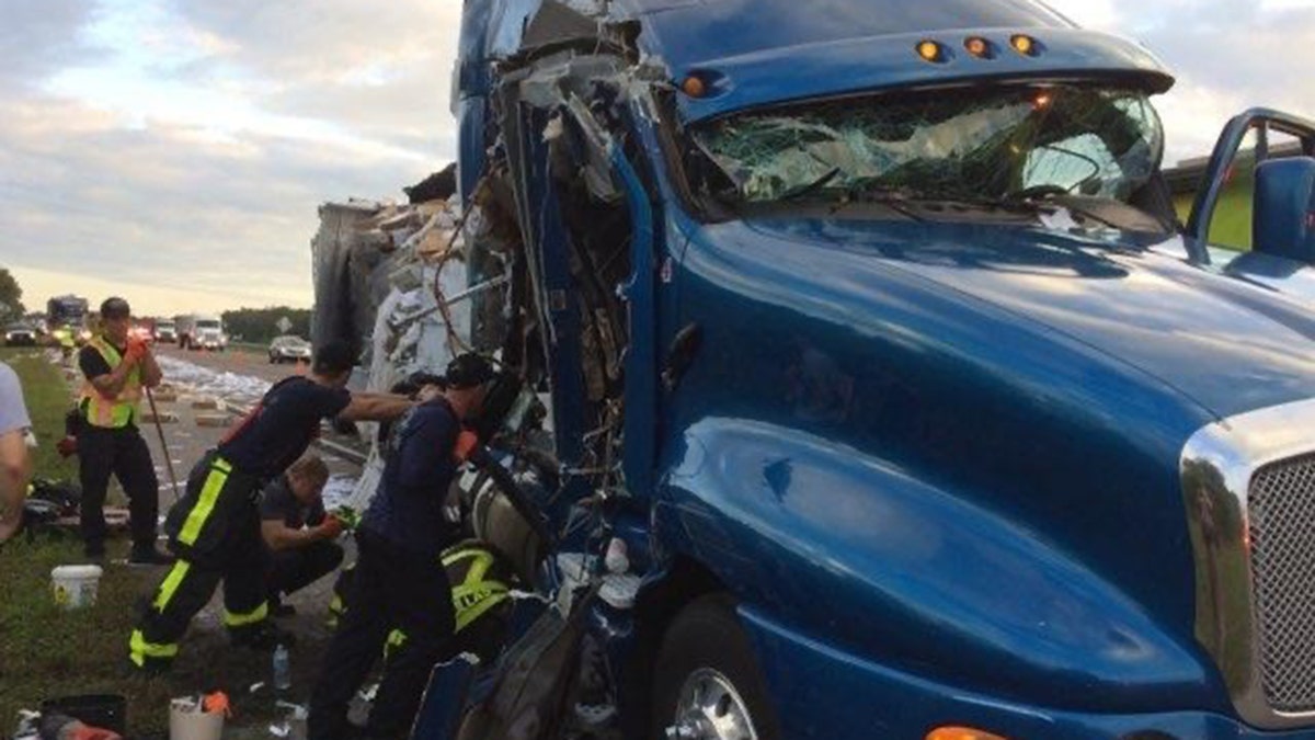 The mail-carrying truck slammed into a tractor-trailer carrying water and produce that was stopped in the southbound shoulder of I-75 on Monday, police said.