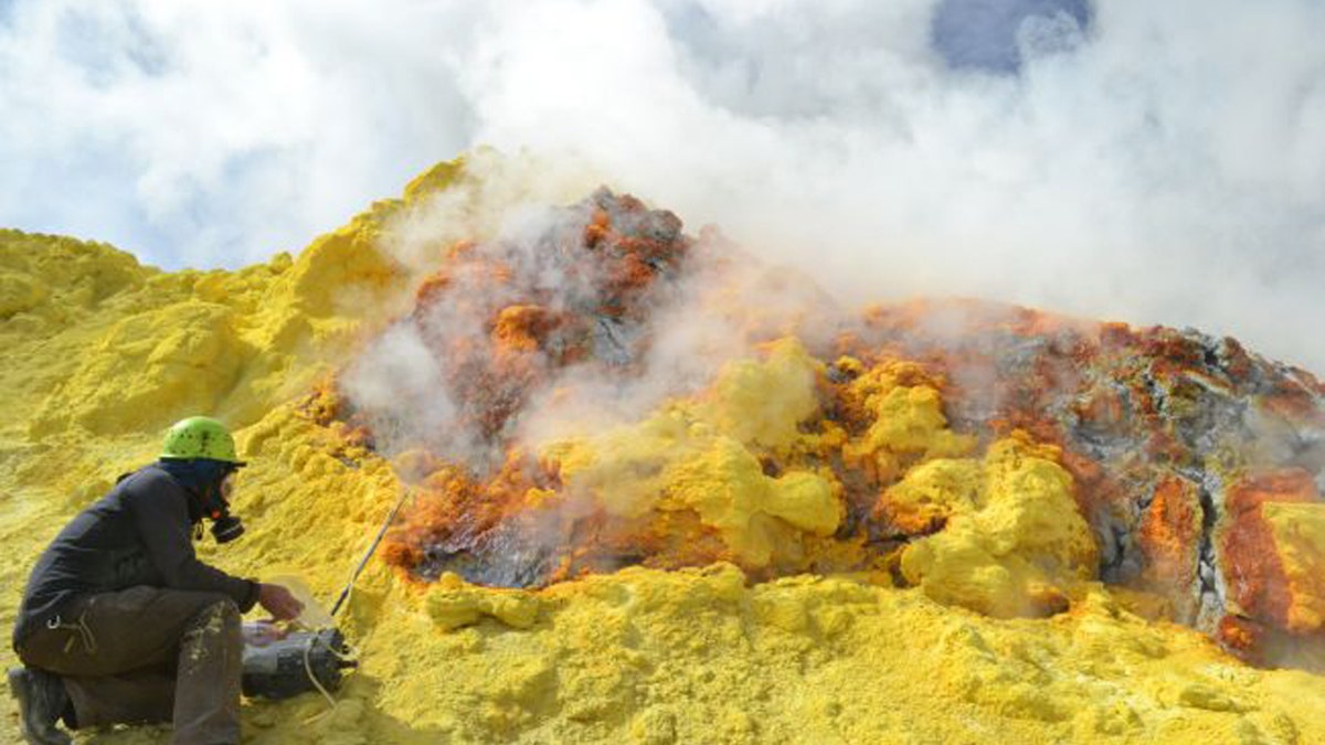 A researcher samples gas emissions released by Lastarria volcano on the border of Chile and Argentina. New research suggests that humans emit about 80 times more CO2 a year than every volcano on Earth combined. (Credit: Yves Moussallam, Lamont Doherty Earth Observatory)