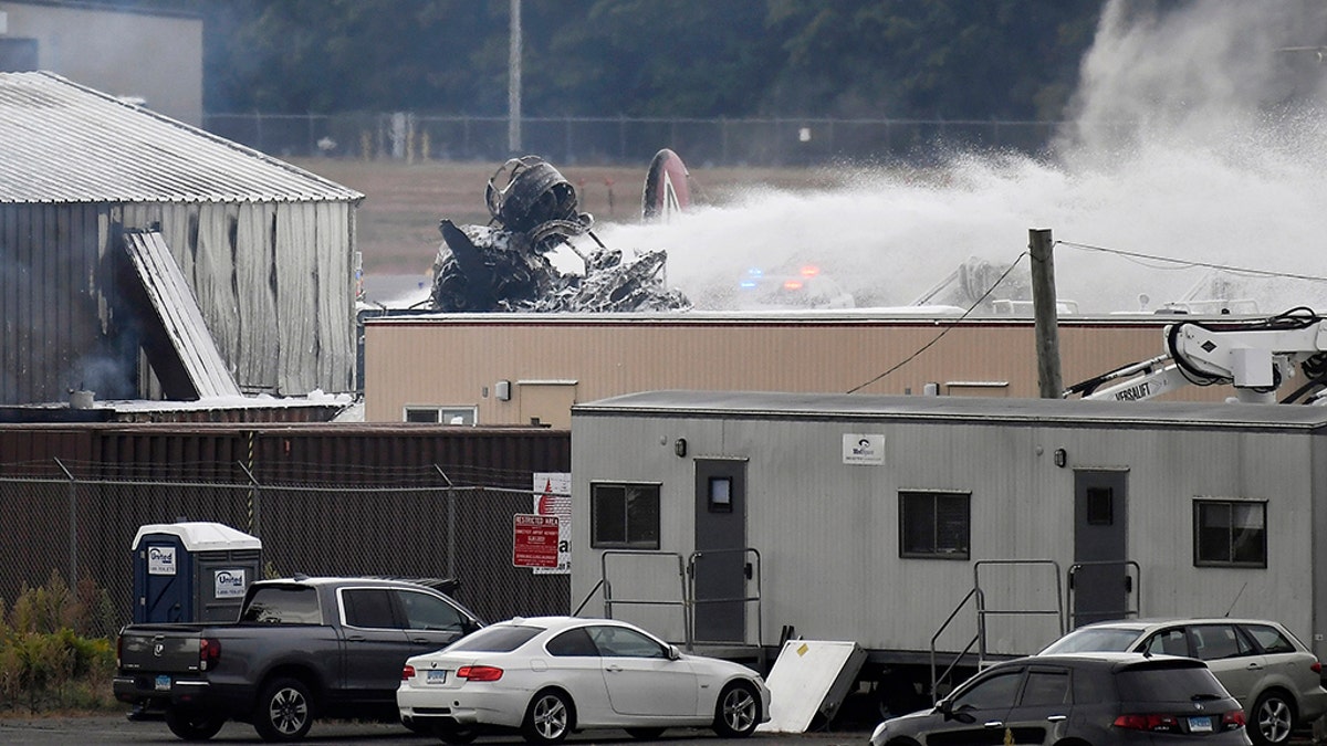 Emergency crews respond after a World War II-era bomber plane crashed at Bradley International Airport in Windsor Locks, Conn., Wednesday, Oct. 2, 2019.