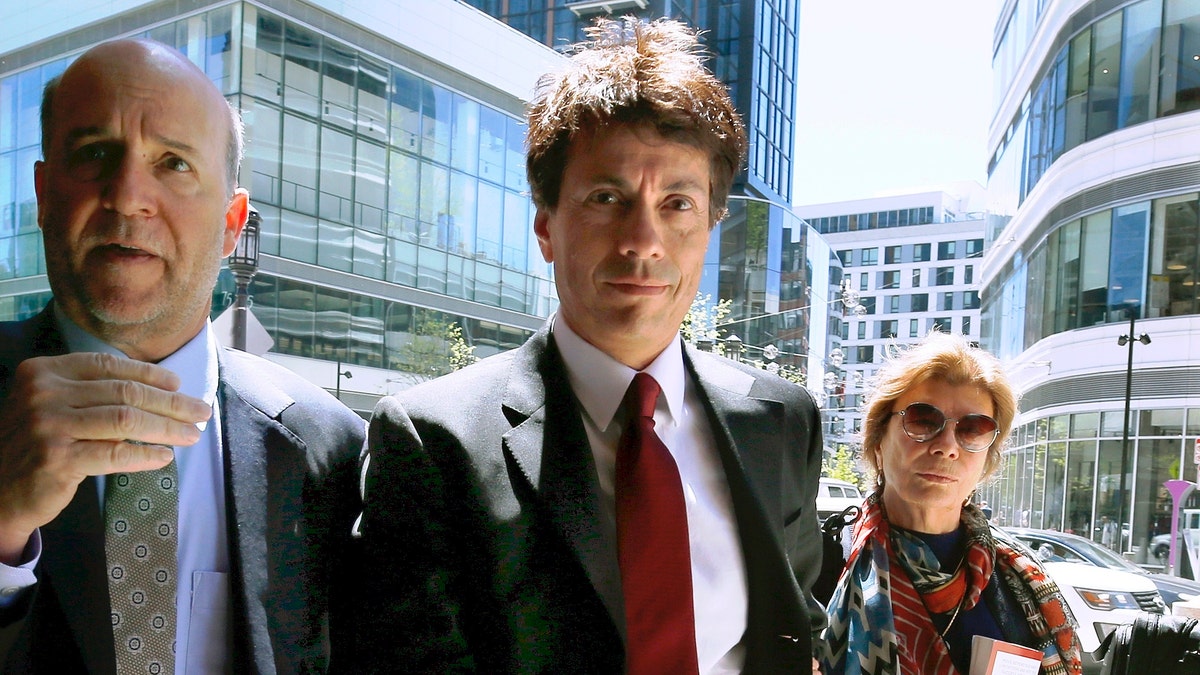 In this May 21 photo, Agustin Huneeus, center, arrives at federal court in Boston. (AP Photo/Michael Dwyer, File)