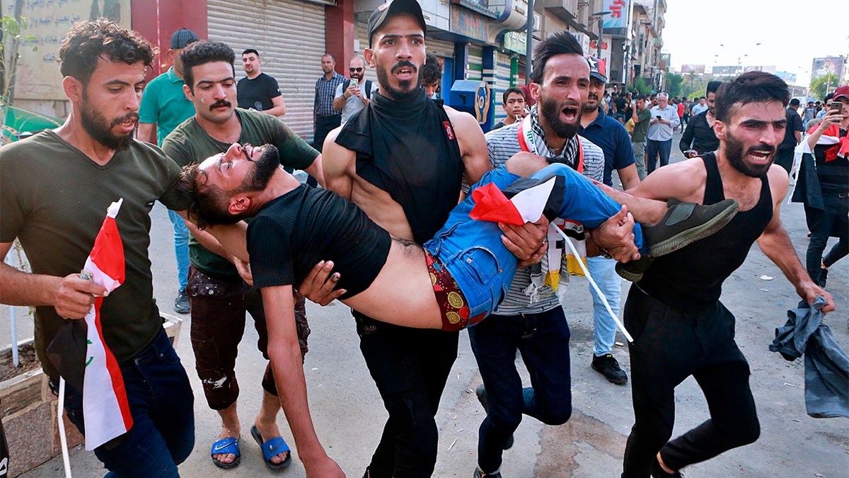 An injured protester is carried off during a protest in Baghdad, Iraq, on Tuesday. (AP Photo/Khalid Mohammed)