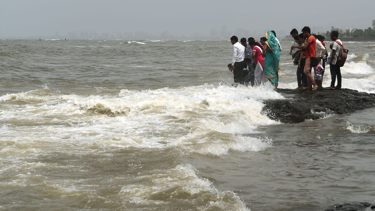 In this photograph taken on September 14, 2019 people gather by the sea during high tide in Mumbai. (PUNIT PARANJPE/AFP/Getty Images)