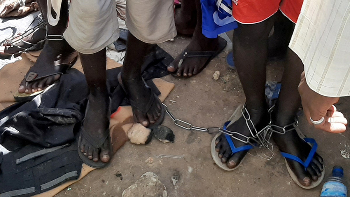 People with chained legs are pictured after being rescued by police in Nigeria