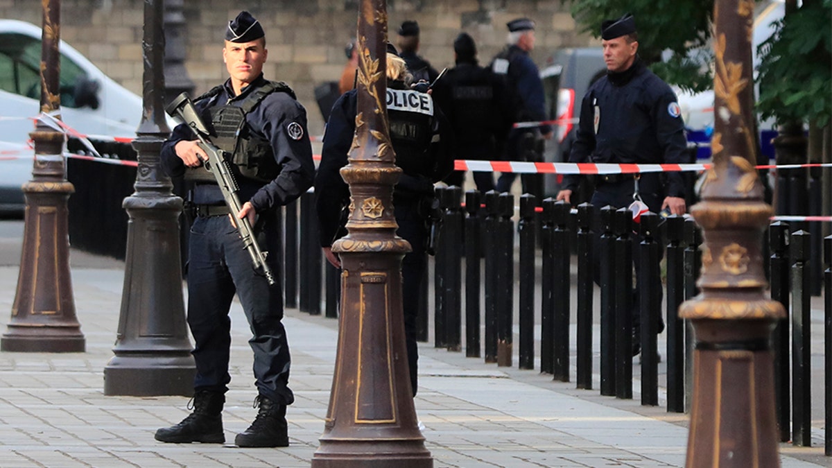 Police officers control the perimeter outside the Paris police headquarters on Thursday after an administrator armed with a knife attacked officers inside. (AP)