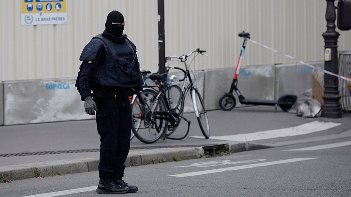 A masked police officer stands next to police tape following the knife attack Thursday. (AP)