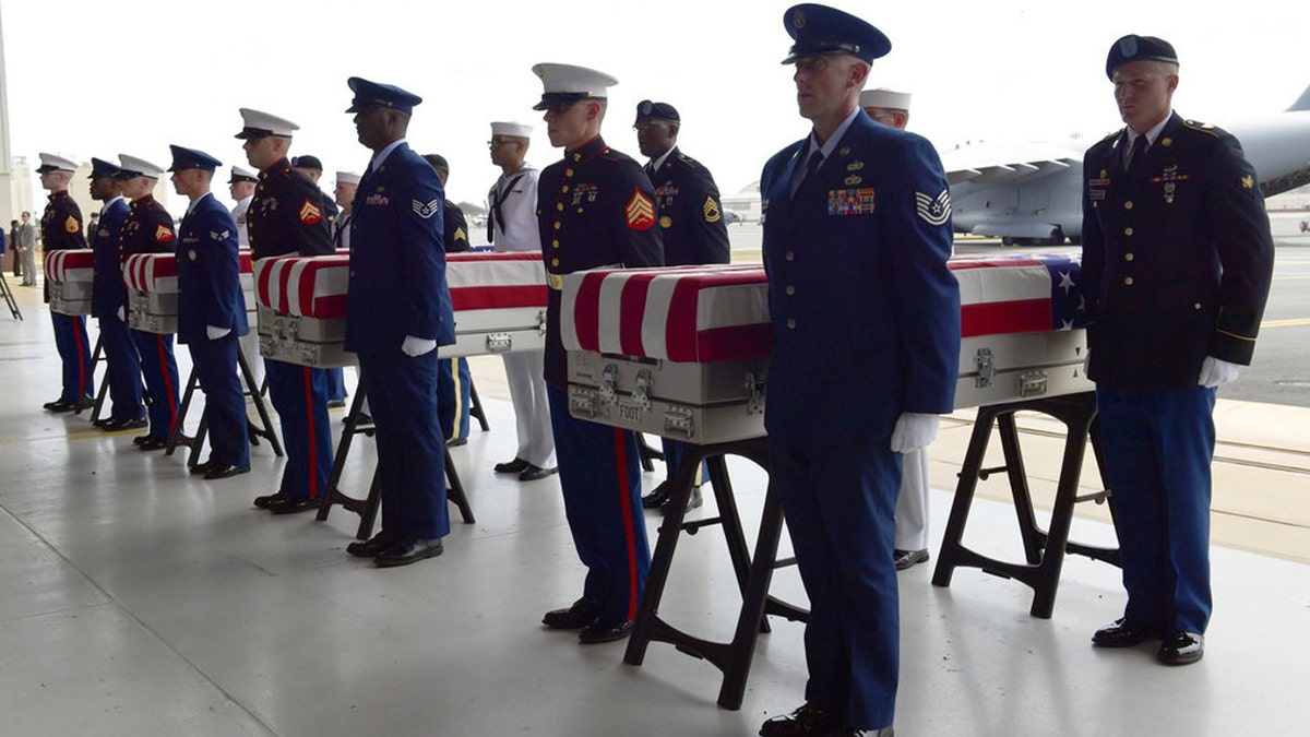 Military members stand at attention after placing transfer cases in a hanger at a ceremony marking the arrival of the remains believed to be of American service members who fell in the Korean War at Joint Base Pearl Harbor-Hickam in Hawaii, in August 2018. (AP)