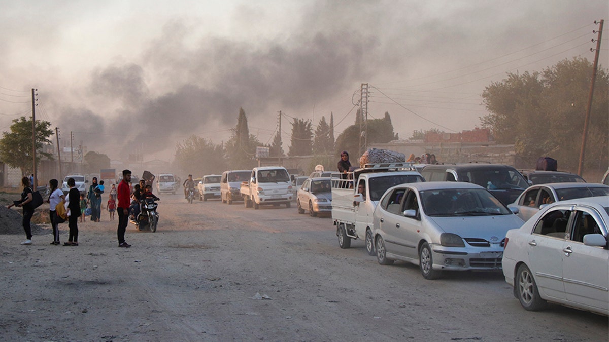 Syrians flee shelling by Turkish forces in Ras al-Ayn, northeast Syria on Wednesday.