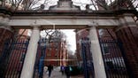 FILE - In this Dec. 13, 2018 file photo, people walk through the gates leading to Harvard Yard at Harvard University in Cambridge, Mass. Harvard's student newspaper is facing a campus backlash over a routine request for government comment about a student demonstration against U.S. Immigration and Customs Enforcement. (AP Photo/Charles Krupa, file)