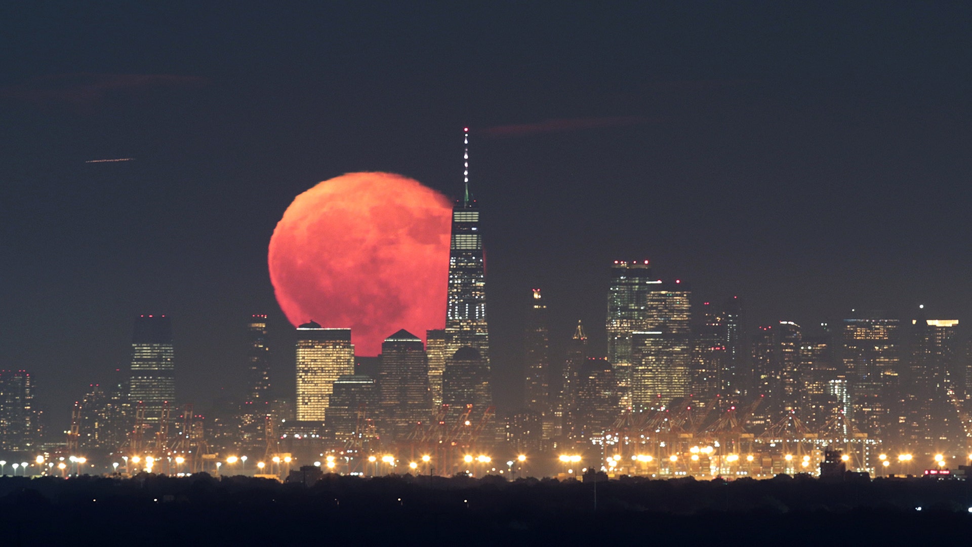 The moon rises behind Lower Manhattan and One World Trade Center in New York City as seen from Green Brook Township, New Jersey, Oct 15, 2019.