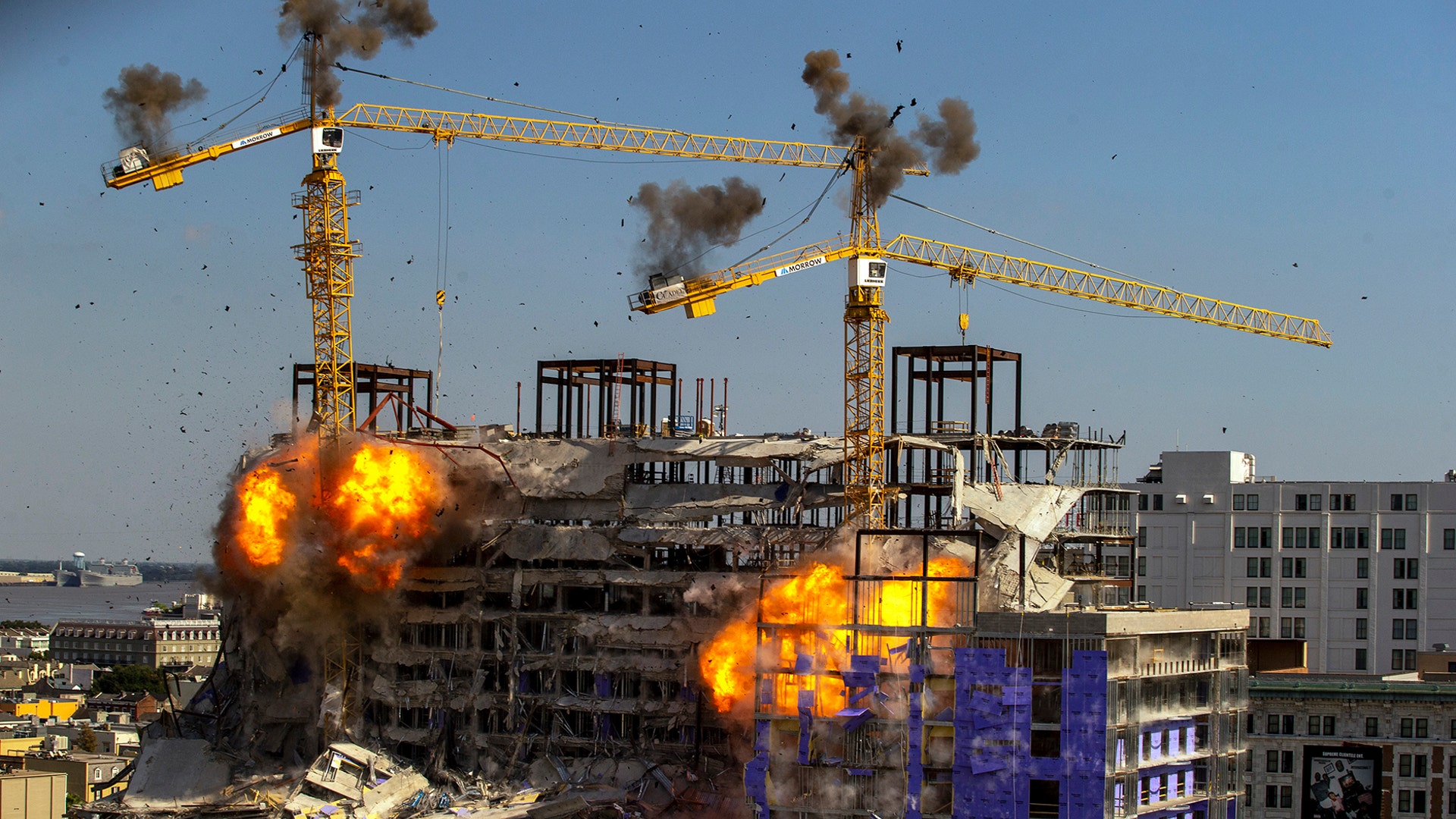 Two unstable cranes at the collapsed Hard Rock Hotel come crashing down after being detonated for implosion in New Orleans, Oct. 20, 2019.