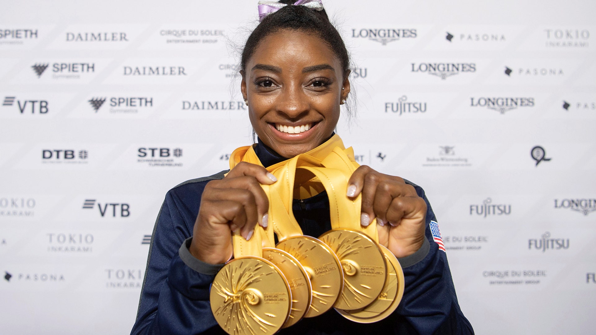 Simone Biles of the United States shows off her five gold medals at the Gymnastics World Championships in Stuttgart, Germany, Oct. 13, 2019.