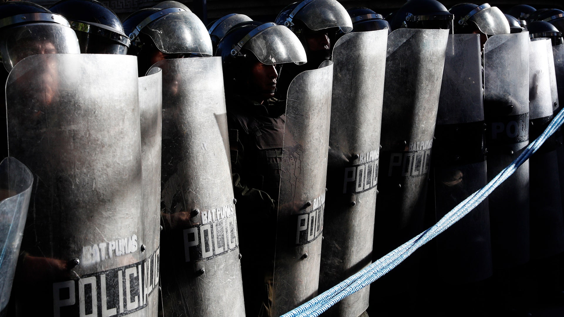 Police stand guard outside the top electoral court where protesters who are against the reelection of President Evo Morales wait for the final results of last weekend's presidential election in La Paz, Bolivia, Oct. 23, 2019. 