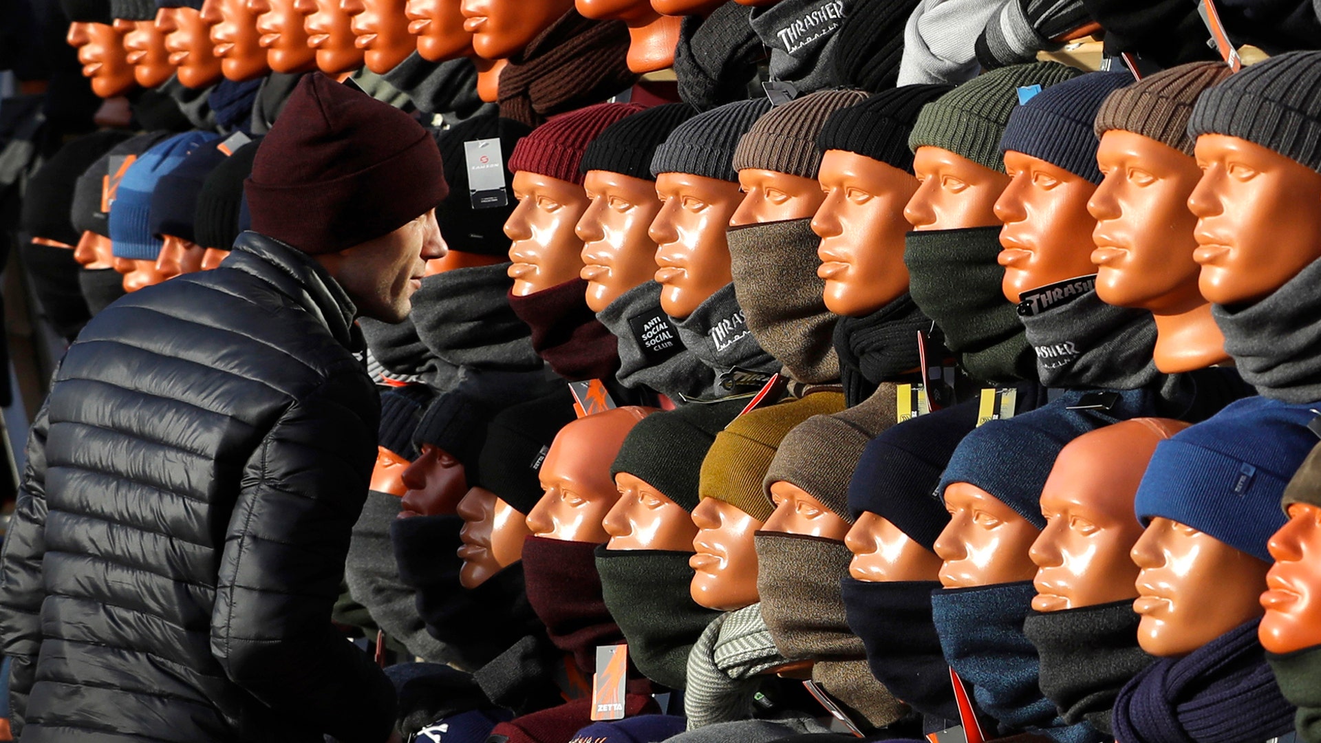 A man looks at himself in a mirror, hidden between mannequins, as he purchases a cap at the clothing market in Minsk, Belarus, Oct. 30, 2019.