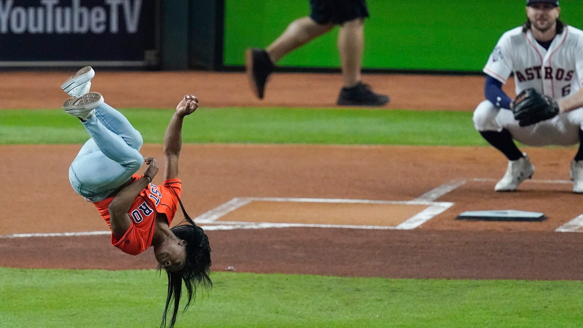 Gymnast Simone Biles does a flip before throwing the ceremonial first pitch before Game 2 of the World Series between the Houston Astros and the Washington Nationals in Houston, Oct. 23, 2019. (AP Photo/Eric Gay)