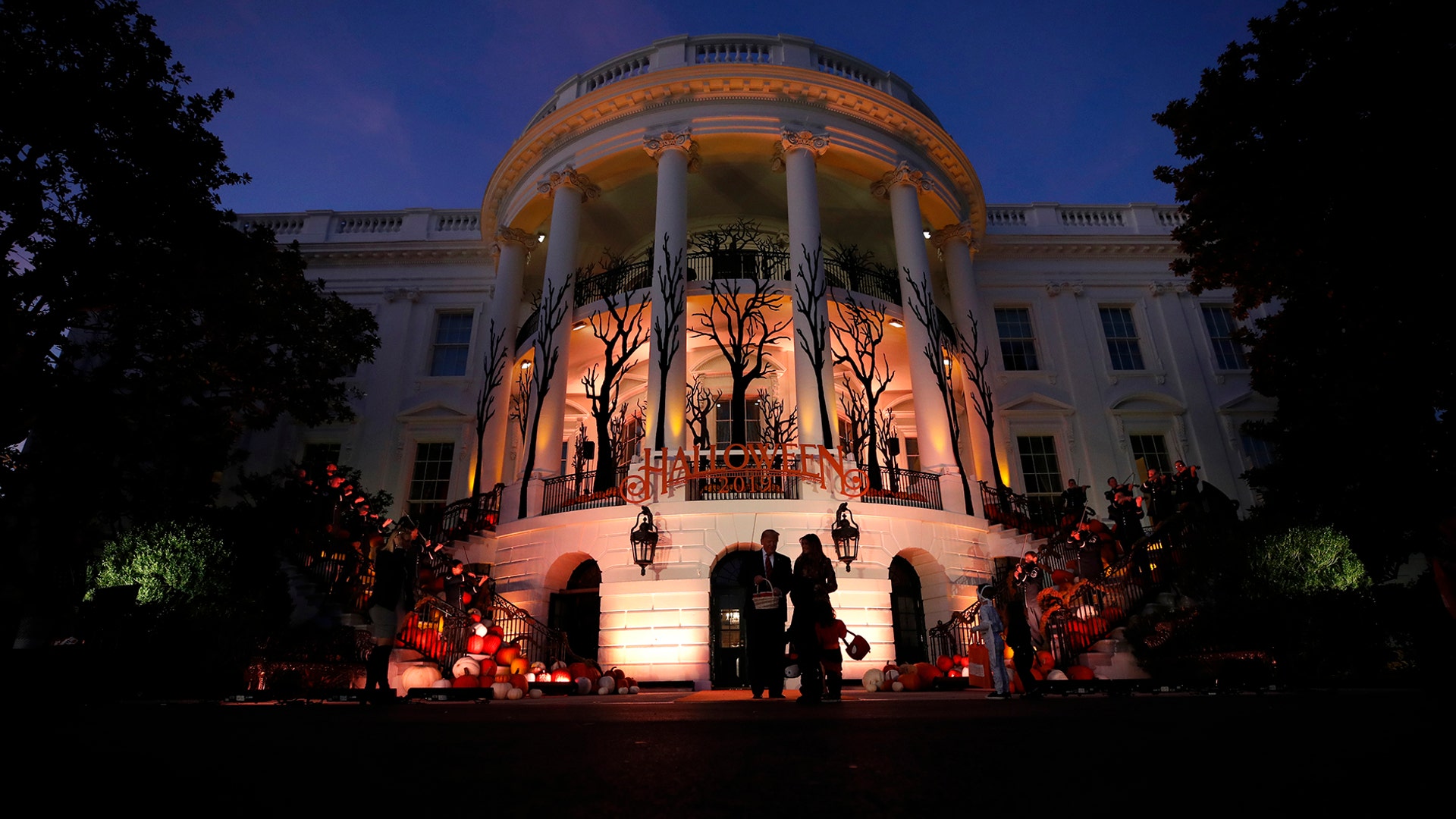 President Donald Trump and first lady Melania Trump give candy to children during a Halloween trick-or-treat event on the South Lawn of the White House in Washington, Oct. 28, 2019. 