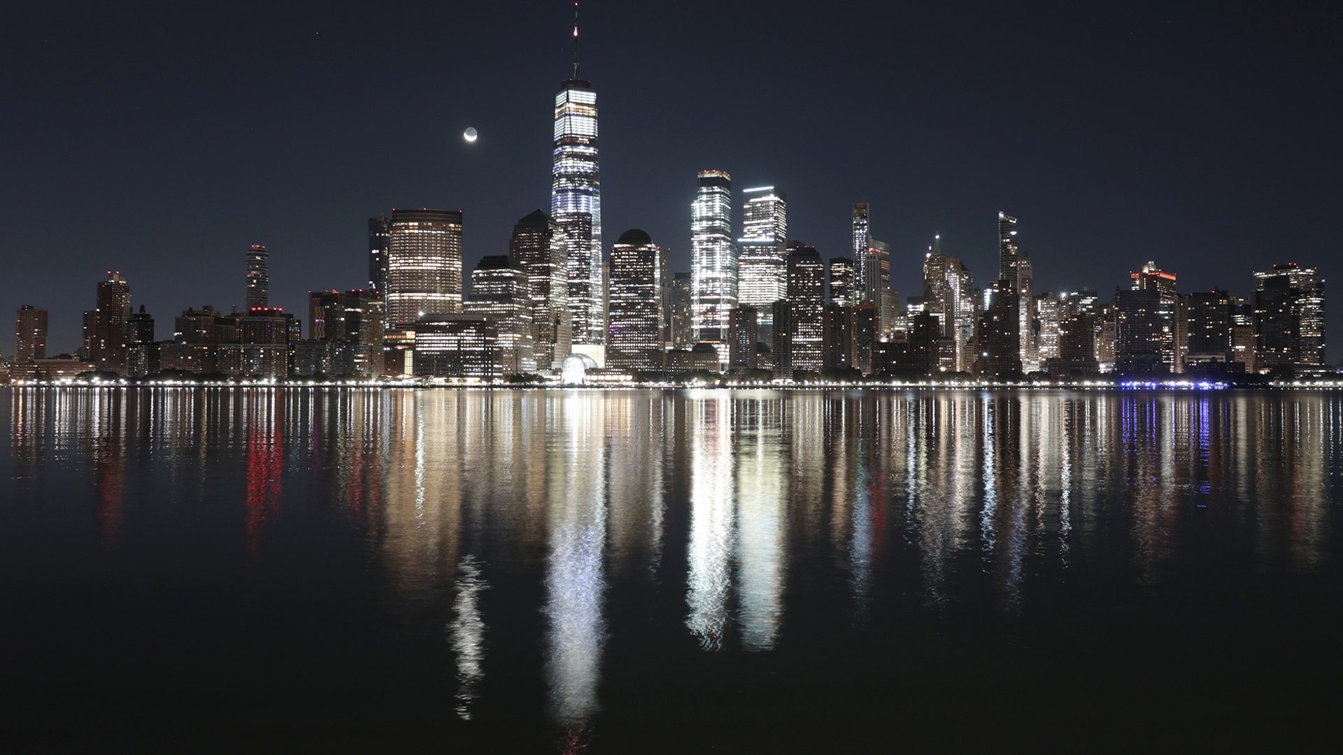 A crescent moon rises in the pre-dawn sky over lower Manhattan and One World Trade Center in New York City, Oct. 25, 2019.