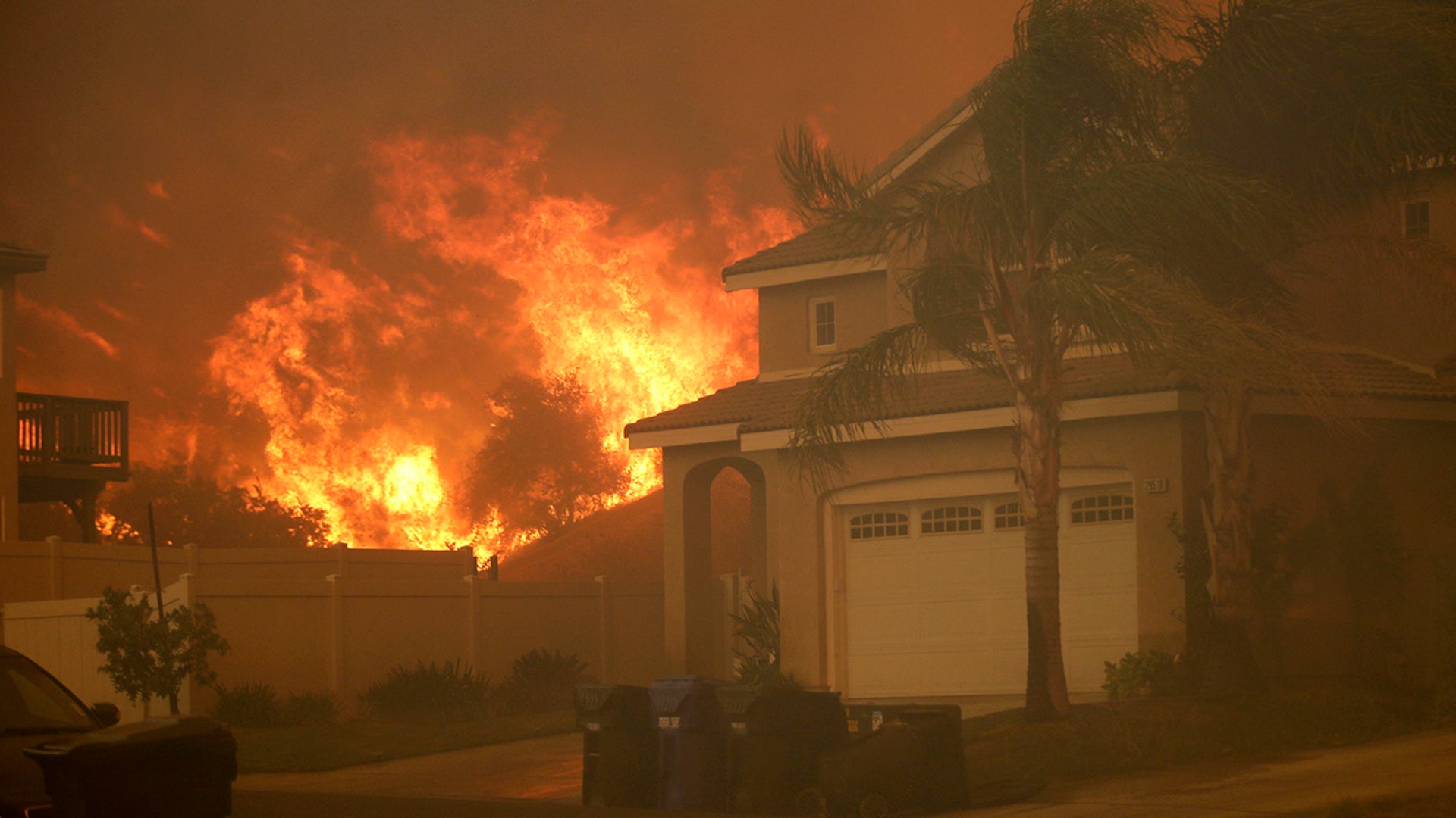 Flames from a wildfire are seen close to a residence Thursday, Oct. 24, 2019, in Santa Clarita, Calif. (AP Photo/Marcio Jose Sanchez)