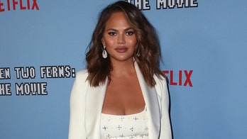 Chrissy Teigen poses topless after getting breast implants removed