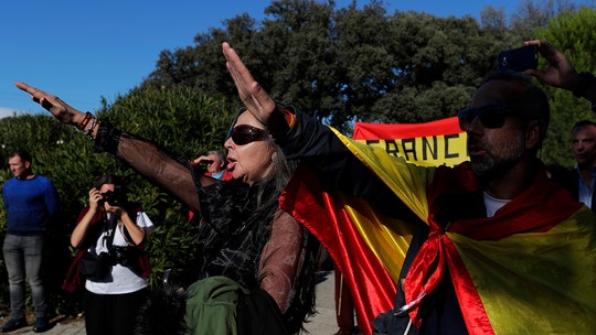 Franco's remains greeted with fascist salutes at new resting place