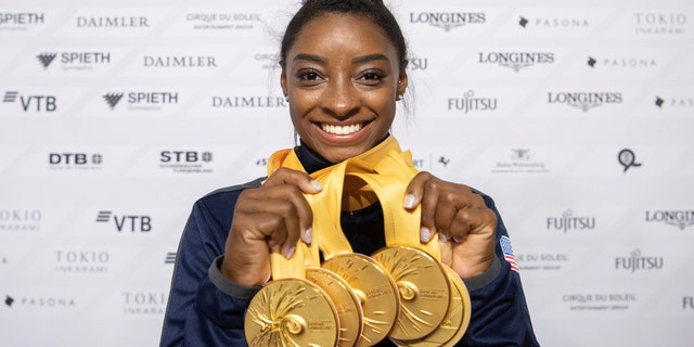 Simone Biles of the United States shows her five gold medals at the Gymnastics World Championships in Stuttgart, Germany, Sunday, Oct. 13, 2019. (Marijan Murat/dpa via AP)