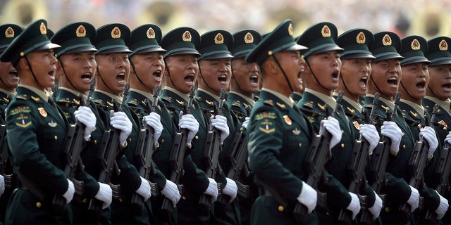 Members of China's People's Liberation Army (PLA) Rocket Force let out a yell as they march in formation during a parade to commemorate the 70th anniversary of the founding of Communist China in Beijing, Tuesday, Oct. 1, 2019. Trucks carrying weapons including a nuclear-armed missile designed to evade U.S. defenses rumbled through Beijing as the Communist Party celebrated its 70th anniversary in power with a parade Tuesday that showcased China's ambition as a rising global force. (AP Photo/Mark Schiefelbein)