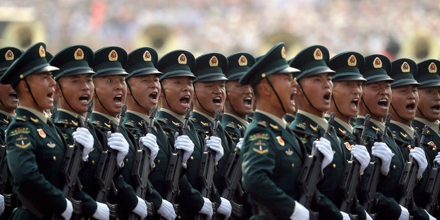 Members of China's People's Liberation Army (PLA) Rocket Force let out a yell as they march in formation during a parade to commemorate the 70th anniversary of the founding of Communist China in Beijing, Tuesday, Oct. 1, 2019. Trucks carrying weapons including a nuclear-armed missile designed to evade U.S. defenses rumbled through Beijing as the Communist Party celebrated its 70th anniversary in power with a parade Tuesday that showcased China's ambition as a rising global force. (AP Photo/Mark Schiefelbein)