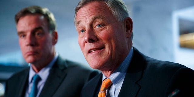 Sen. Richard Burr, R-N.C., right, chairman of the Senate Intelligence Committee, and Sen. Mark Warner, D-Va., committee vice chair, speak to the media after receiving closed briefings from Acting Director of National Intelligence Joseph Maguire and National intelligence inspector general Michael Atkinson, Thursday Sept. 26, 2019, on Capitol Hill in Washington. Burr on Tuesday said that a DOJ investigation into pre-pandemic stock trades he made is closed. (AP Photo/Jacquelyn Martin)