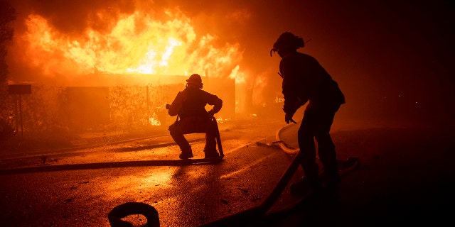 Firefighters try to save a home on Tigertail Road during the Getty fire, Monday, Oct. 28, 2019, in Los Angeles, Calif.
