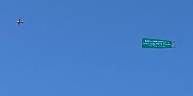 President Donald Trump's re-election campaign flies a banner reading “SOCIALISM DESTROYS OHIO JOBS. VOTE TRUMP