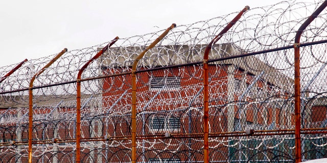 In this March 16, 2011, file photo, a security fence surrounds inmate housing on the Rikers Island correctional facility in New York.