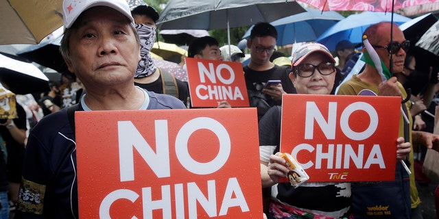 Hong Kong students and Taiwanese supporters hold slogans during a march in Taipei, Taiwan, Sunday, Sept. 29, 2019.