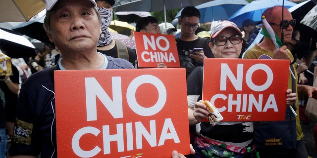 Hong Kong students and Taiwanese supporters hold slogans during a march in Taipei, Taiwan, Sunday, Sept. 29, 2019. The demonstration was part of global "anti-totalitarianism" rallies in over 60 cities worldwide, including in Australia and Taiwan, to denounce "Chinese tyranny." (AP Photo/Chiang Ying-ying)