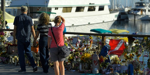 In this Sept. 6 photo, people visit a growing memorial to the victims who died aboard a dive boat that caught fire. (AP Photo/Mark J. Terrill,File)