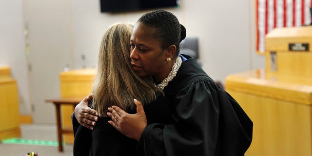 State District Judge Tammy Kemp gives former Dallas Police Officer Amber Guyger a hug before Guyger leaves for jail, Wednesday, Oct. 2, 2019, in Dallas. Guyger, who said she mistook neighbor Botham Jean's apartment for her own and fatally shot him in his living room, was sentenced to a decade in prison. (Tom Fox/The Dallas Morning News via AP, Pool)