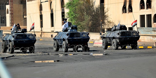 Iraqi security forces close a bridge road near the site of the protests in Tahrir Square in central Baghdad on Saturday. Curfew was lifted Saturday, days after authorities imposed it in an attempt to quell anti-government demonstrations that have turned deadly. (AP Photo/Hadi Mizban)