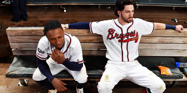 Atlanta Braves' Dansby Swanson, right, and Ozzie Albies sit in the dugout after the Braves lost 13-1 to the St. Louis Cardinals in Game 5 of their National League Division Series baseball game Wednesday, Oct. 9, 2019, in Atlanta. (AP Photo/John Amis)