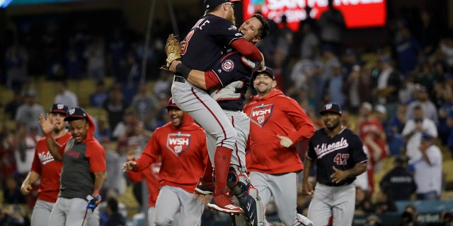 Washington Nationals pitcher Sean Doolittle, left, and catcher Yan Gomes leap in celebration after the team's 7-3 win in Game 5 of a baseball National League Division Series against the Los Angeles Dodgers on Wednesday, Oct. 9, 2019, in Los Angeles.